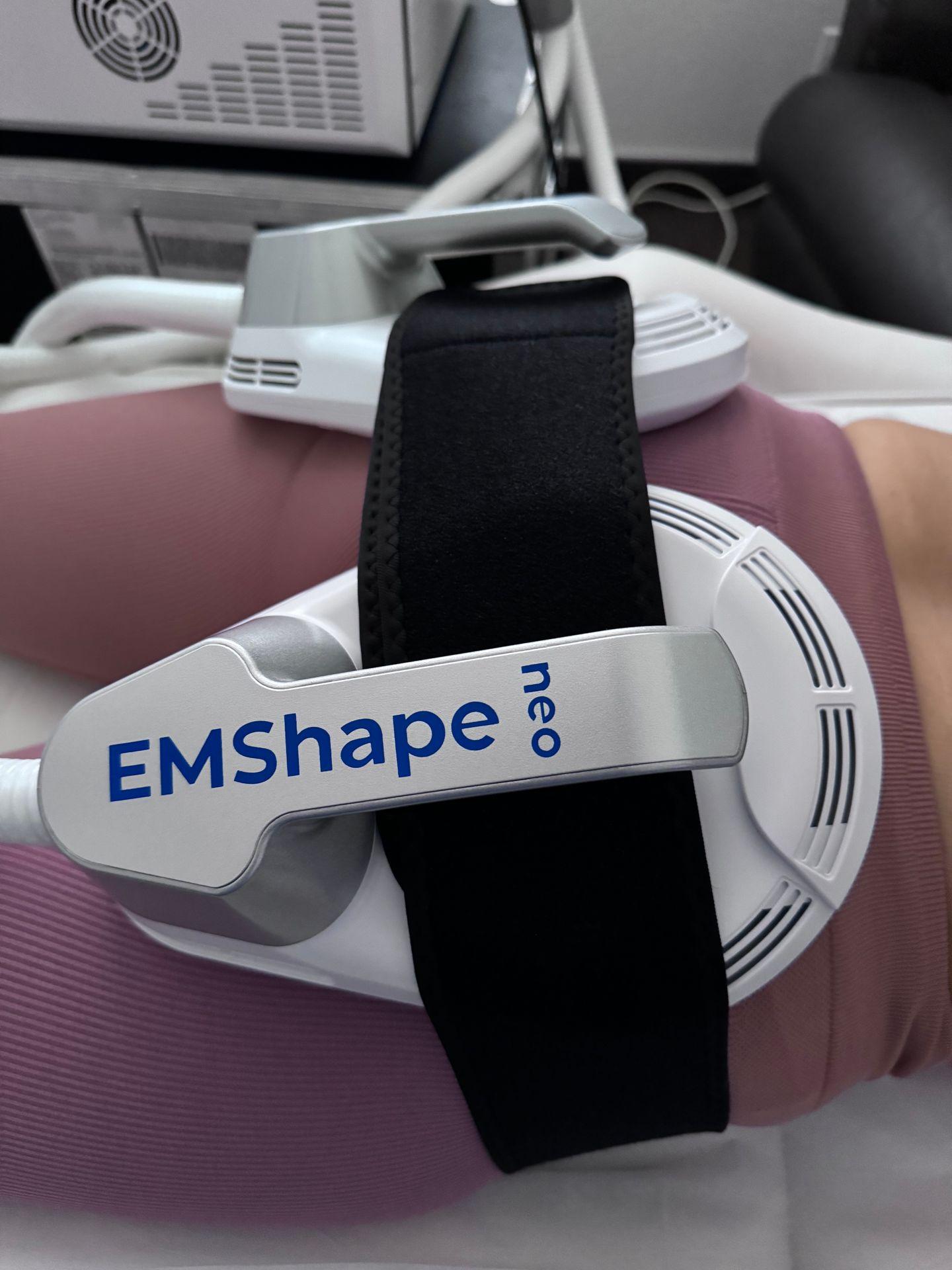 Close-up of EMShape neo device attached to a person's leg in a clinical setting.