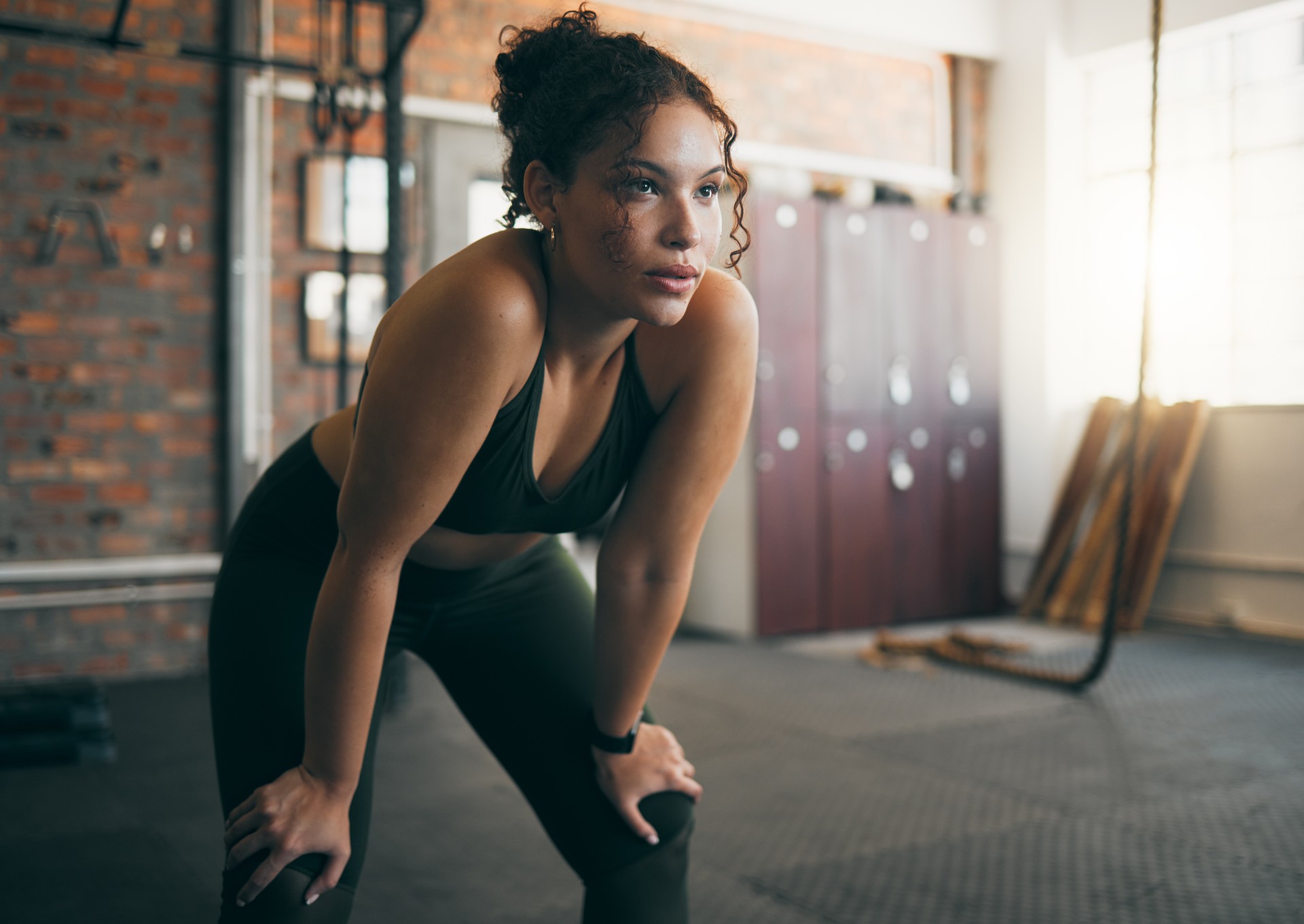 Tired, exercise and woman at gym after fitness workout or training for health and body wellness. Young sports female or athlete resting on break while thinking about goals, progress and performance