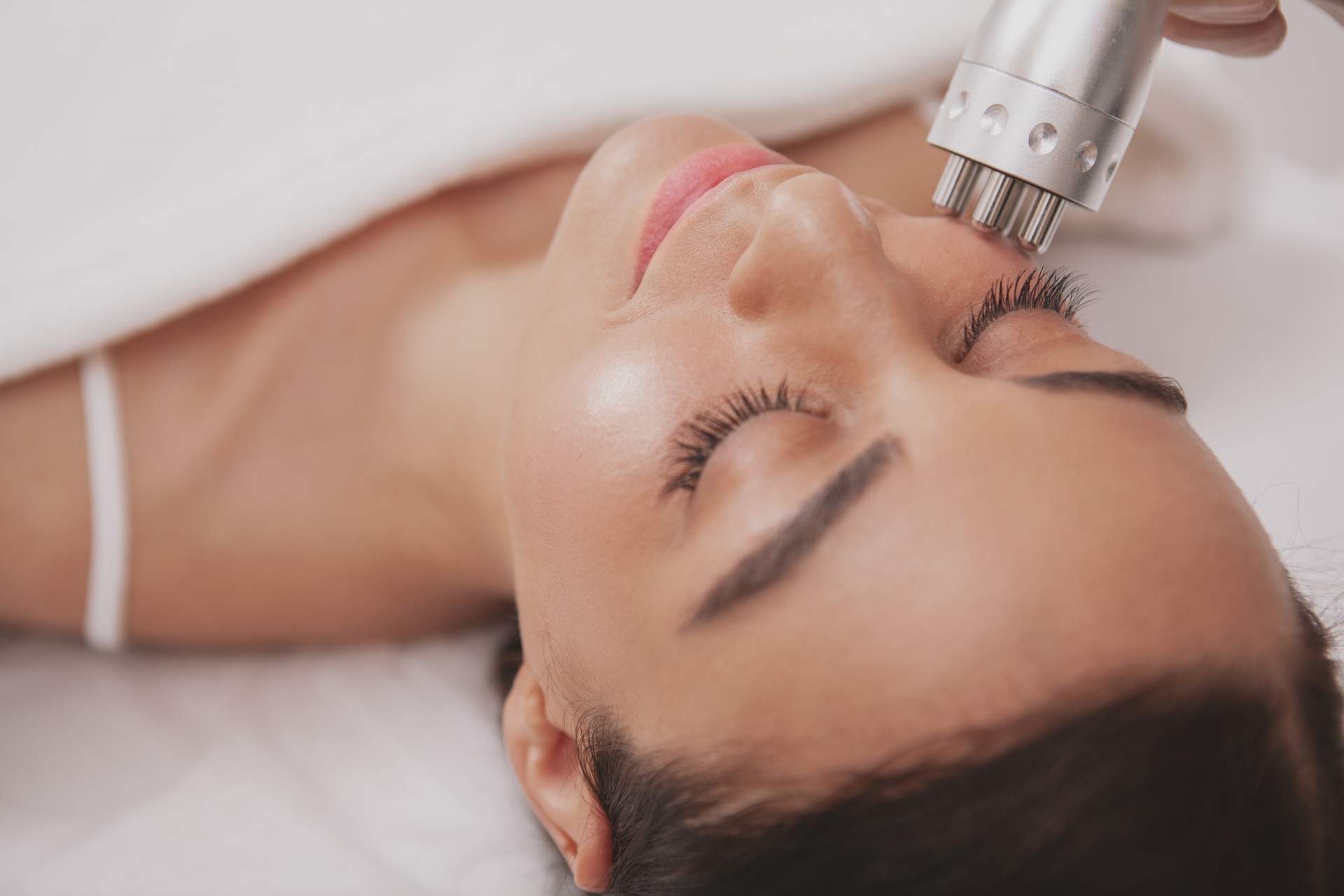 Beautiful young woman getting facial skincare treatment